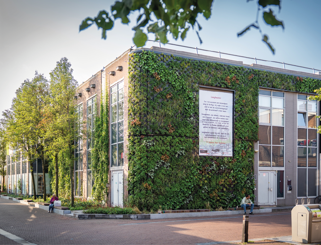 http://Een%20gevel%20van%20een%20gebouw%20die%20volledig%20groen%20is%20door%20planten.